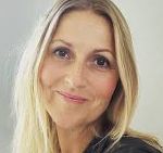 Porträt einer Person mit blonden Haaren und freundlichem Ausdruck.